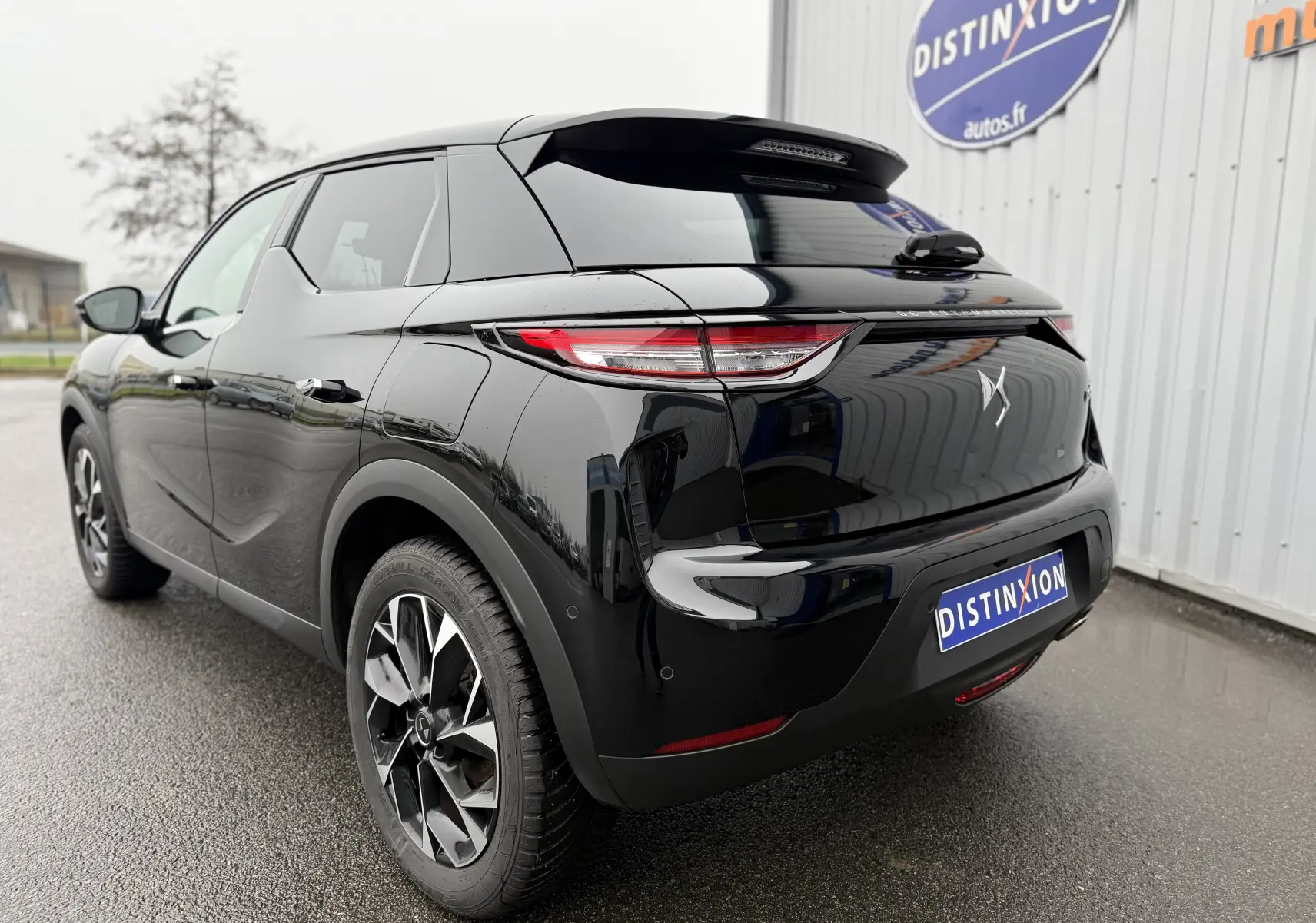 Vue 3/4 arrière droite du DS3 2024 noir Perla Nera avec jantes bi-ton et feux arrière LED distinctifs.