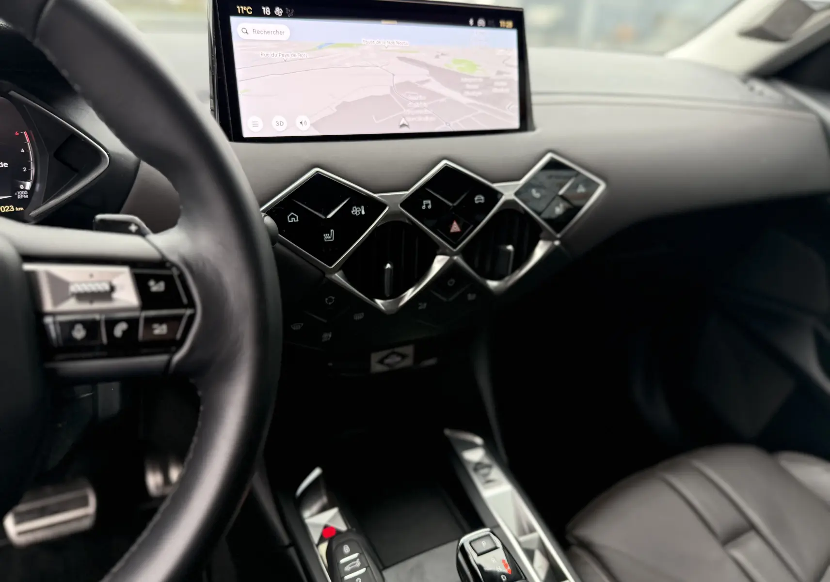 Intérieur du DS3 2024 en noir Perla Nera, vue côté conducteur sur tableau de bord avec écran tactile et commandes en losange.