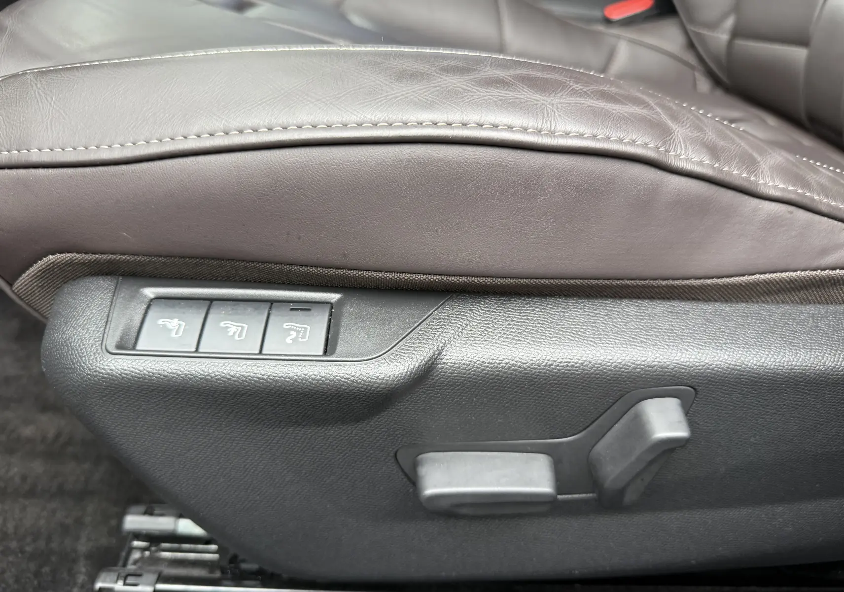 Gros plan sur les commandes électriques du siège avant en cuir marron du DS3 Noir Perla Nera 2024.