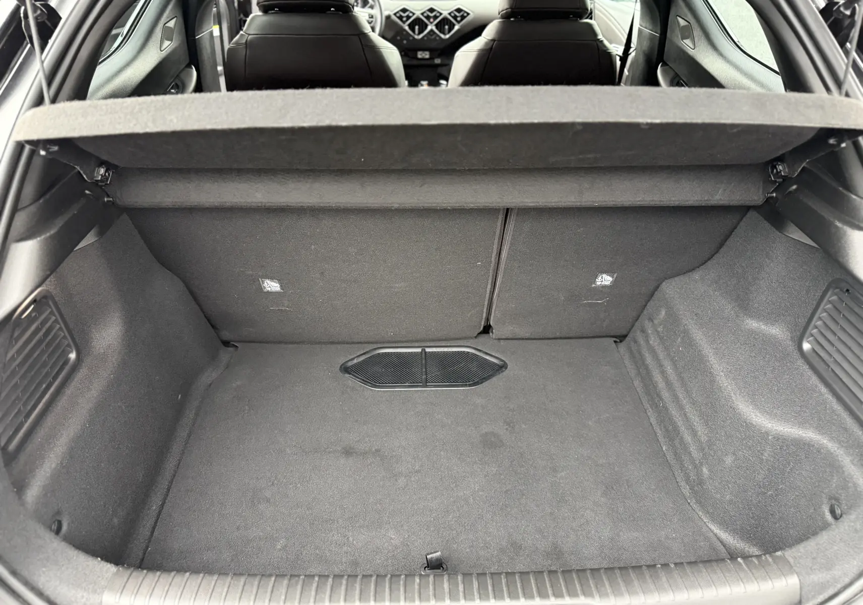 Coffre vide vu de l'arrière d'une DS3 2024 noir Perla Nera, avec banquette arrière et sièges avant en cuir visibles.