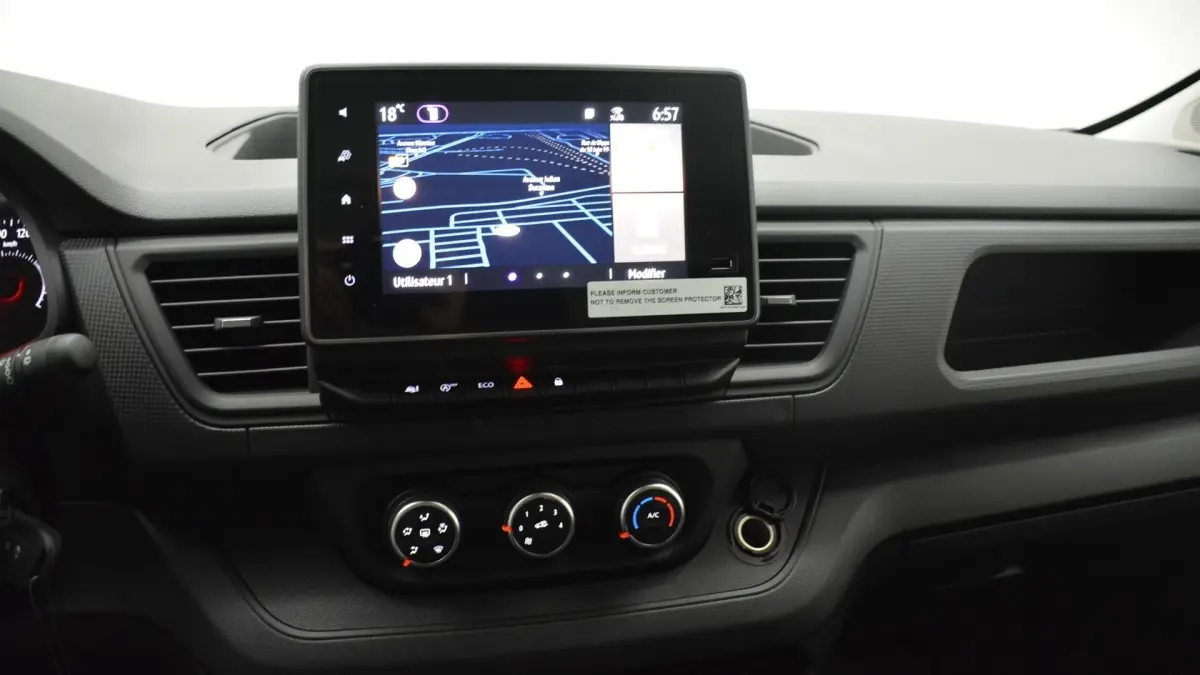 Tableau de bord central du Renault Trafic Fourgon gris clair 2025 avec écran tactile 8 pouces et commandes climatisation visibles.