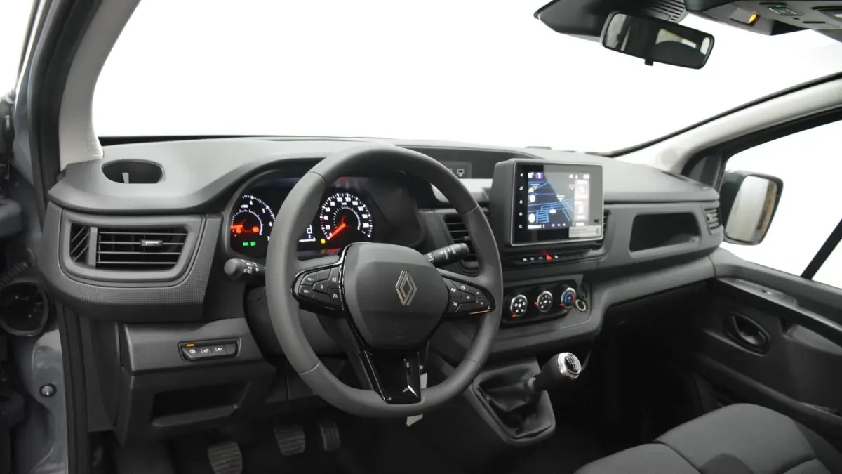Vue intérieure côté conducteur du tableau de bord gris clair du Renault Trafic Fourgon avec volant multifonctions et écran tactile central.