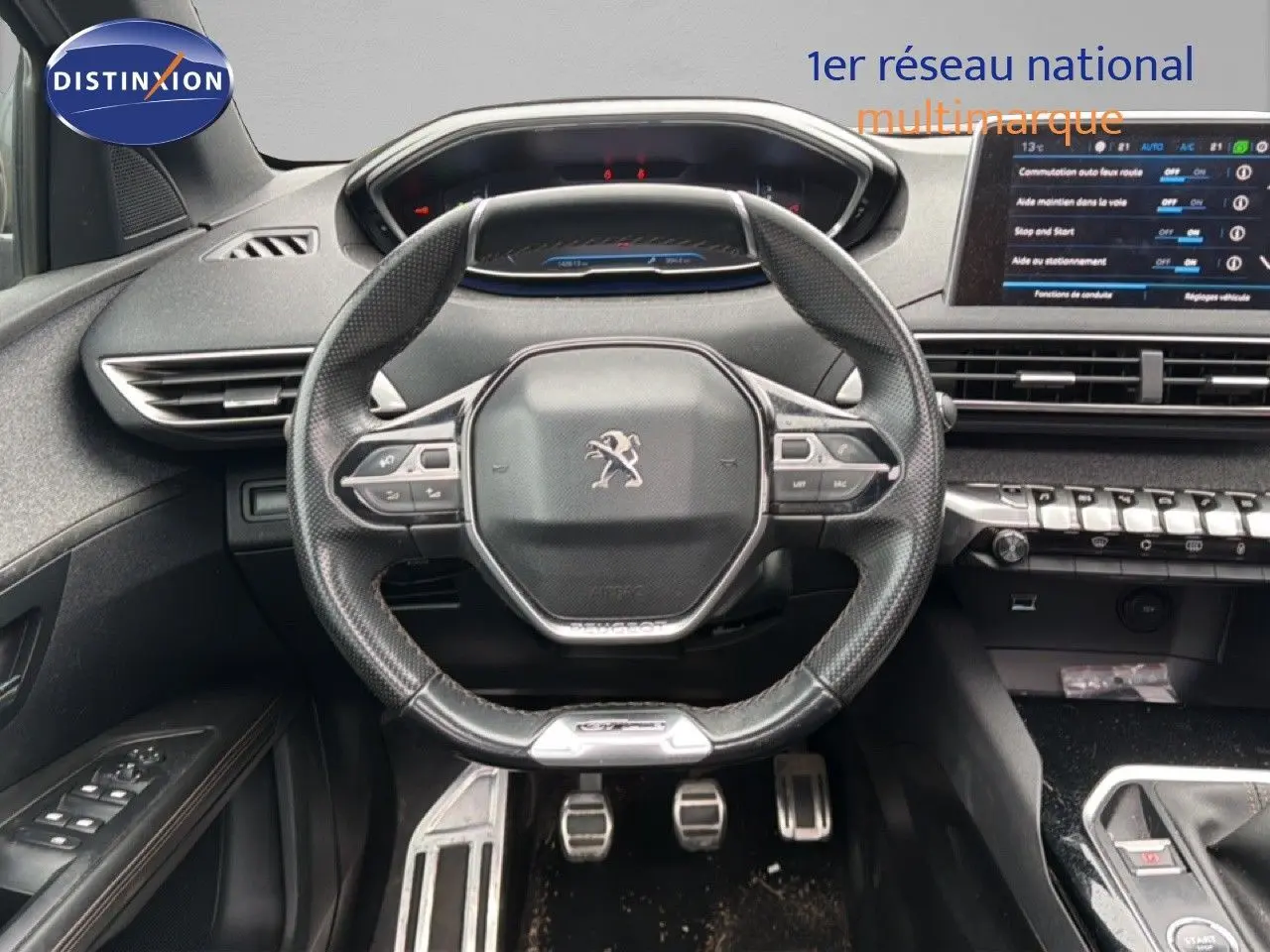 Vue intérieure centrée sur le volant cuir noir et le tableau de bord numérique du Peugeot 5008 GT Line 2018.