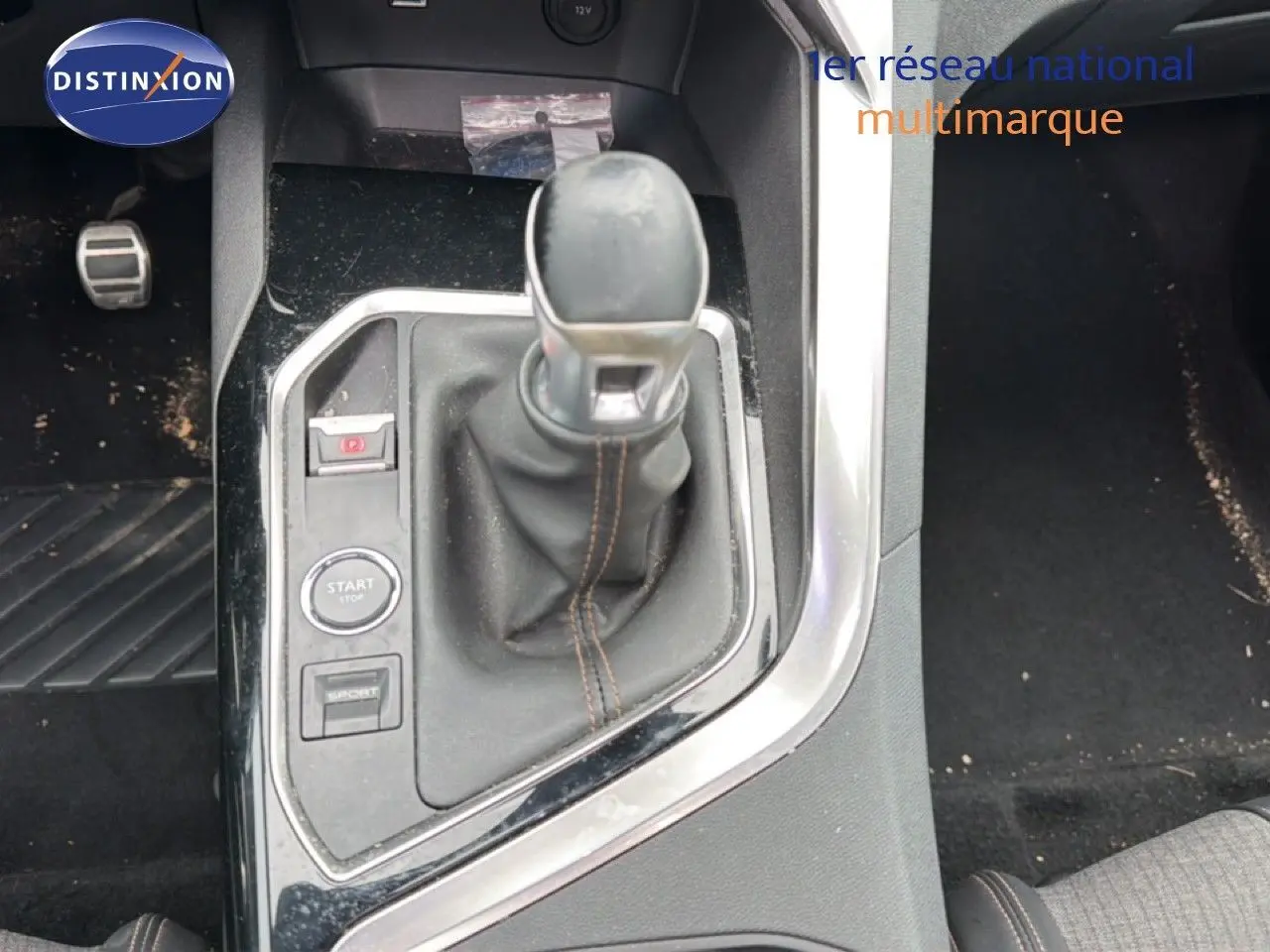 Vue rapprochée de la console centrale du Peugeot 5008 2018, levier de vitesse manuel avec surpiqûres marron.