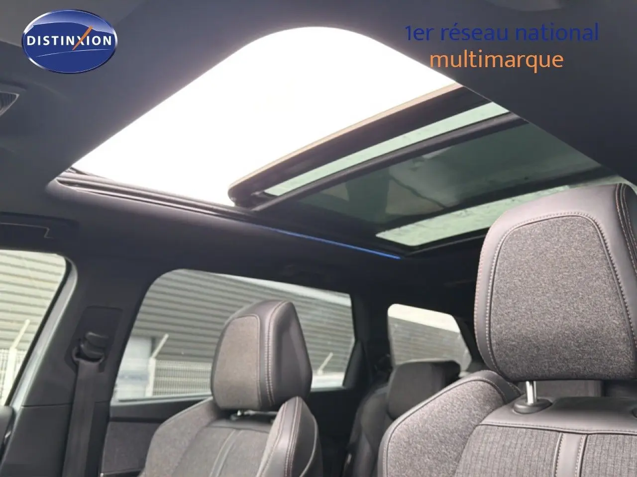 Vue intérieure du toit ouvrant panoramique et des sièges avant en tissu gris du Peugeot 5008 GT Line 2018.
