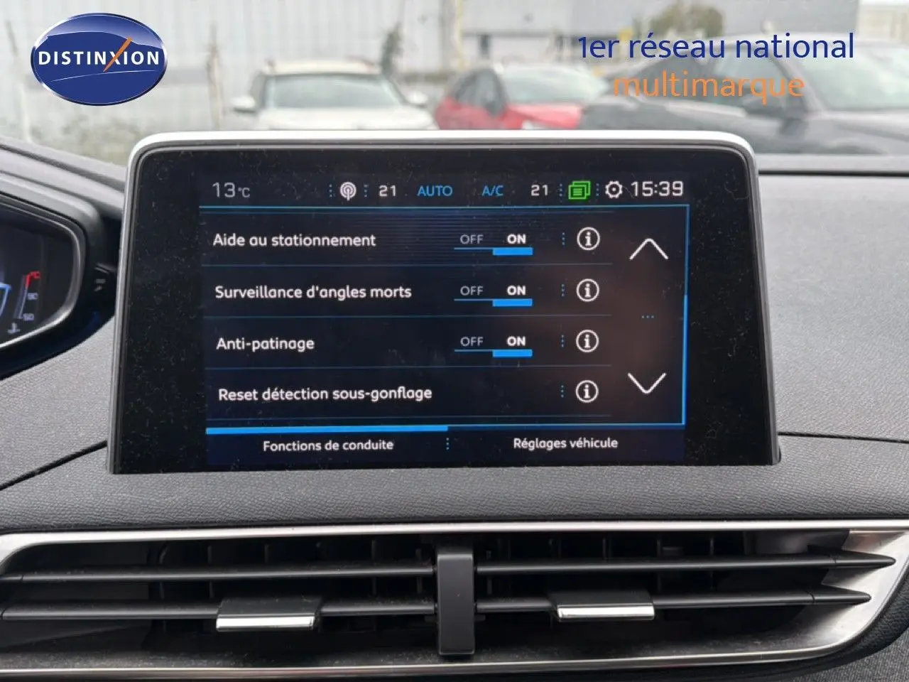 Vue intérieure centrée sur l’écran tactile du tableau de bord du Peugeot 5008 gris Artense, affichant les aides à la conduite.