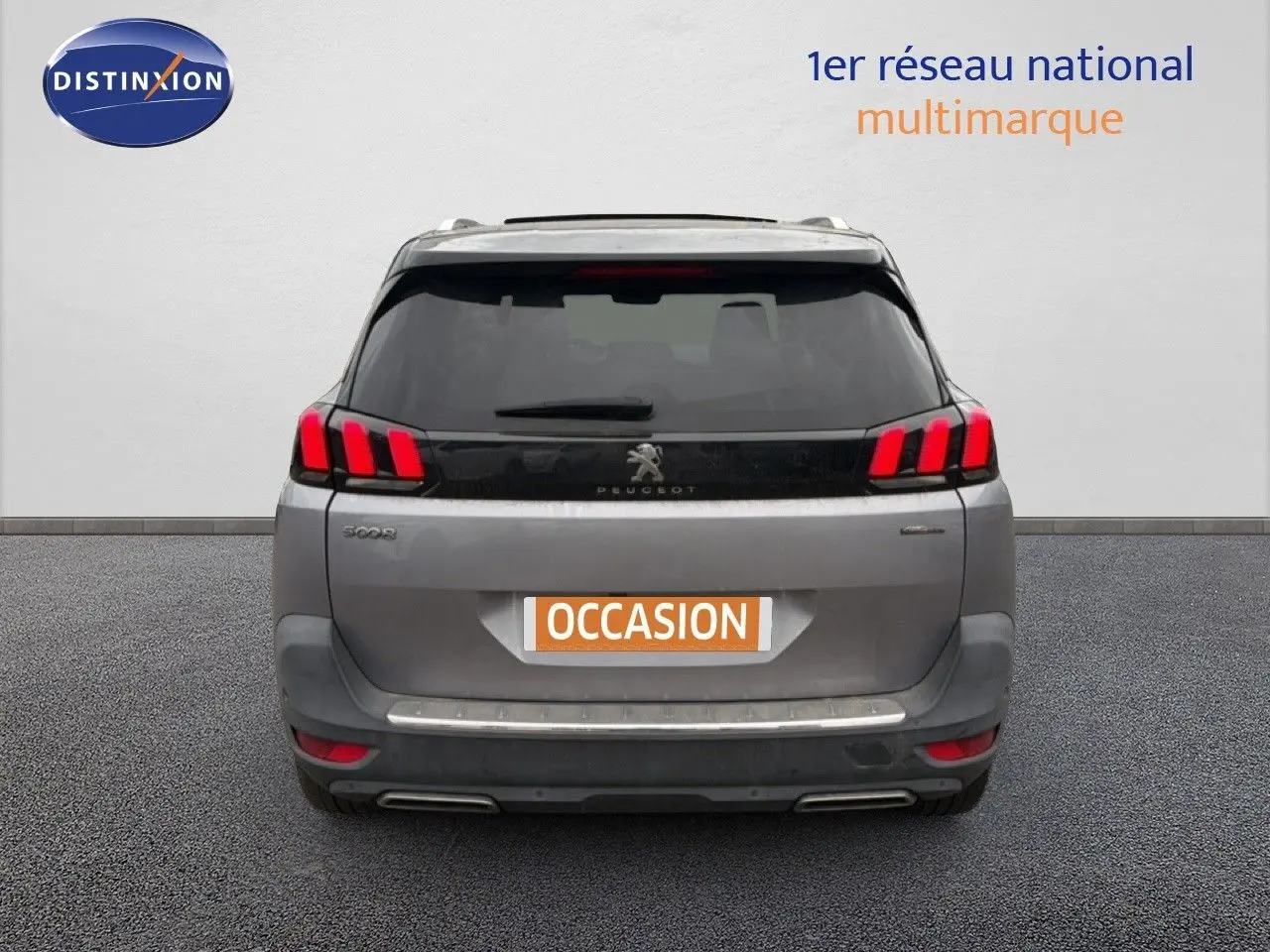 Vue arrière d’un Peugeot 5008 gris Artense avec feux LED distinctifs et double sortie d’échappement chromée.