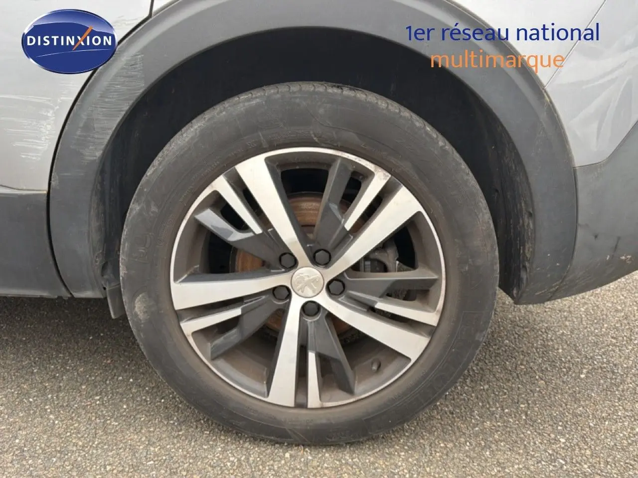 Gros plan sur la roue avant droite avec jante alliage bicolore du Peugeot 5008 gris Artense.
