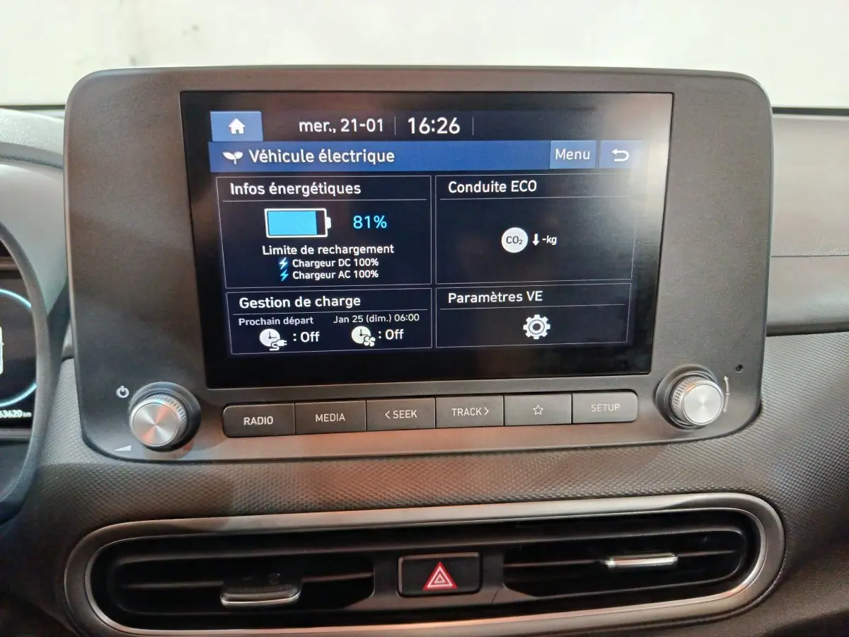 Écran tactile central affichant les infos de charge d’une Hyundai Kona électrique, vue de face intérieur.