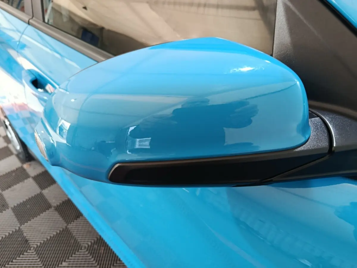 Rétroviseur côté conducteur bleu vif du Hyundai Kona électrique 2022, avec clignotant intégré noir.