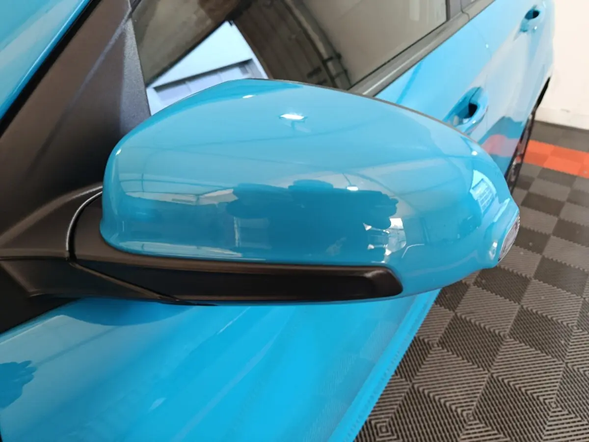 Rétroviseur côté gauche bleu électrique du Hyundai Kona BEV 64kWh 2022, vue rapprochée sur la portière et poignée.