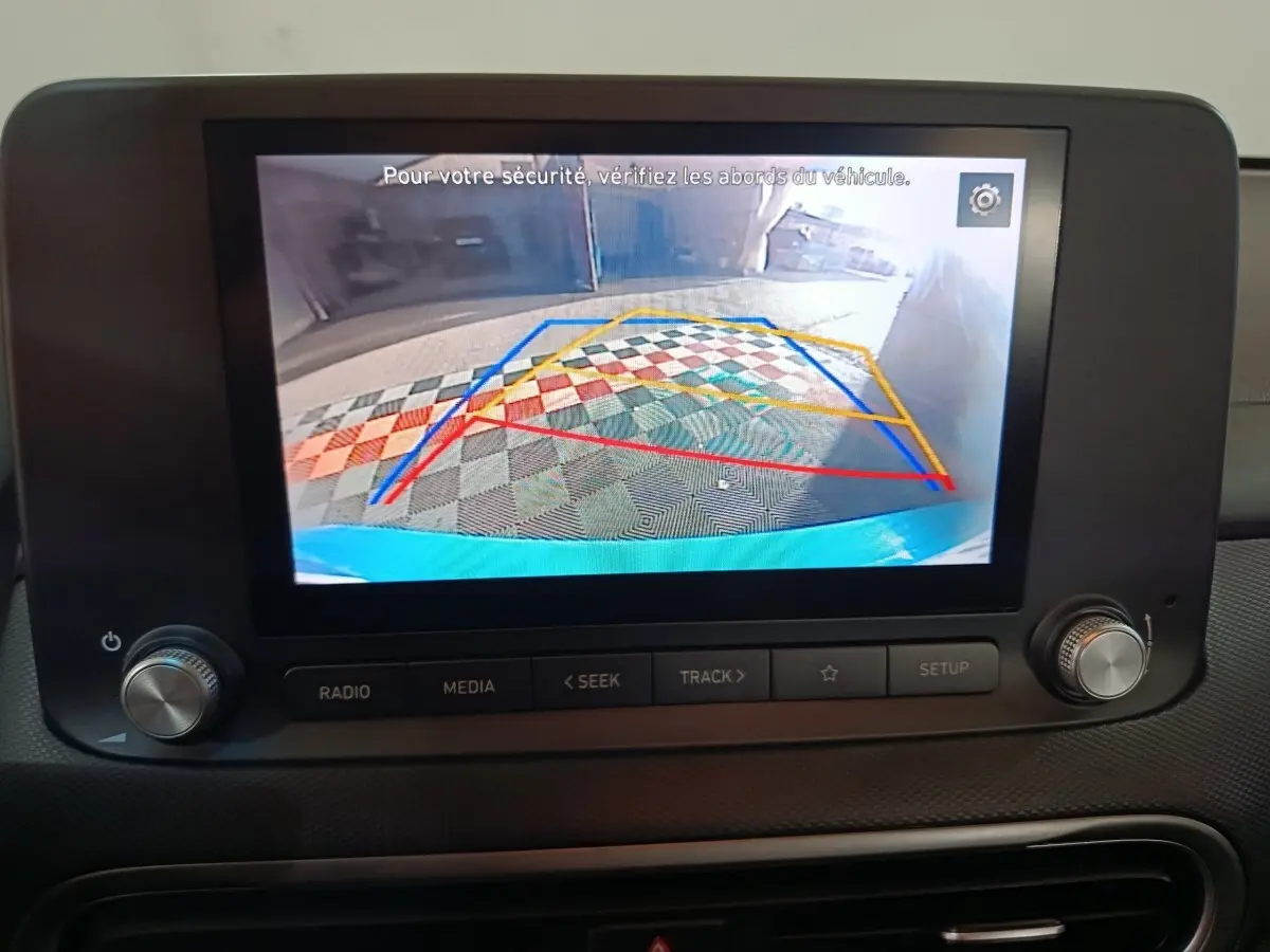 Écran tactile central montrant la caméra de recul avec guidage coloré, intérieur du Hyundai Kona bleu 2022.