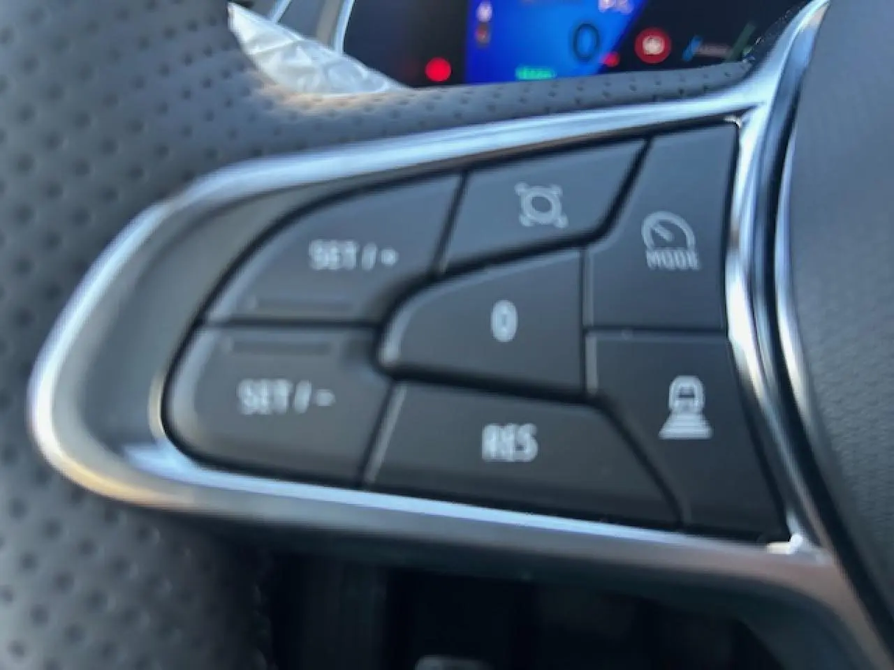 Gros plan sur les commandes noires du volant en textile de la Renault Symbioz 2025, avec contour chromé.