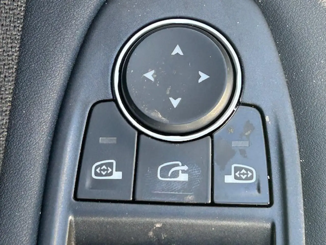 Gros plan sur les commandes de réglage des rétroviseurs intérieurs d’une Renault Symbioz blanc nacré.