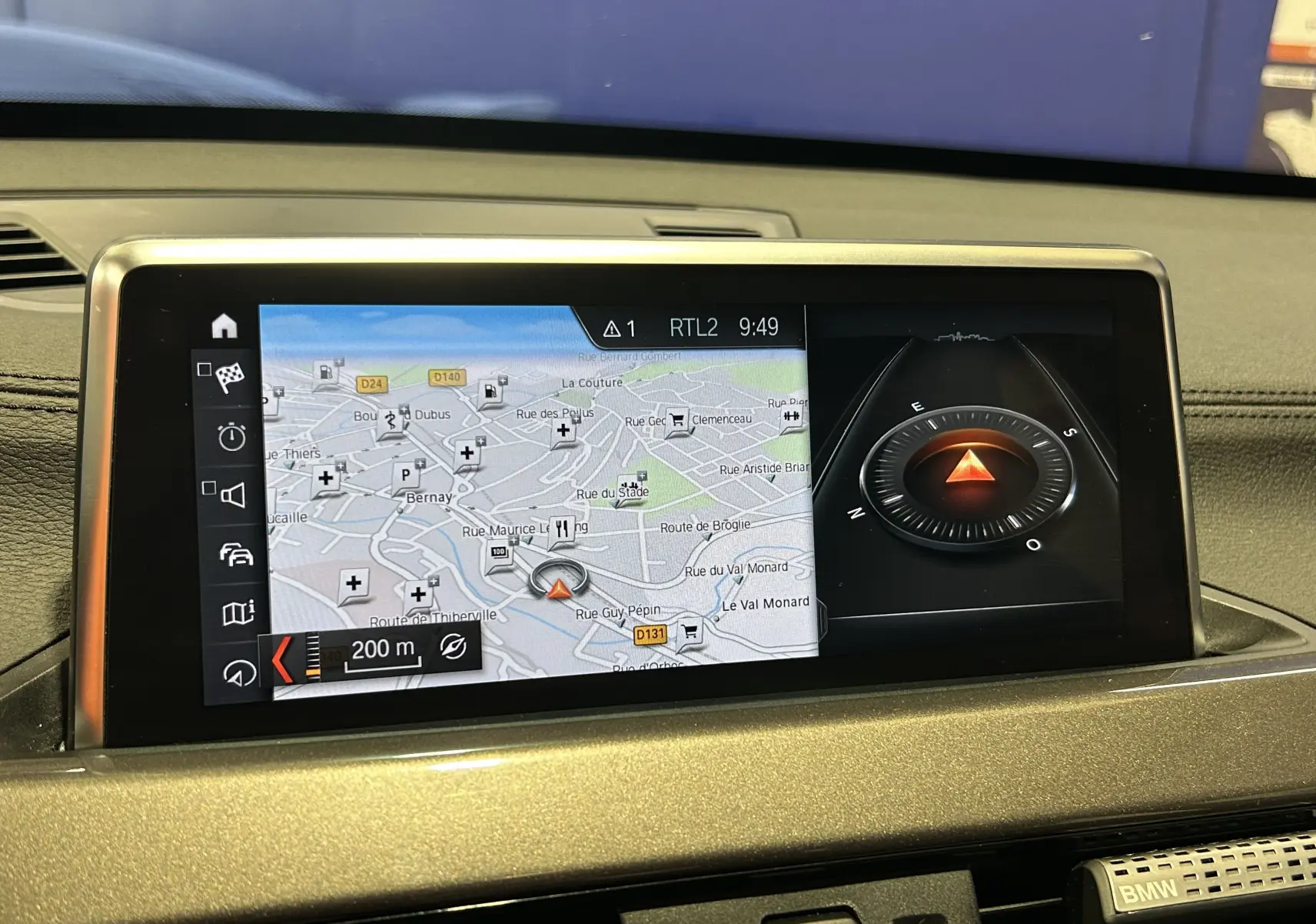 Écran central du tableau de bord du BMW X1 gris 2021 affichant la navigation avec carte et boussole digitale.