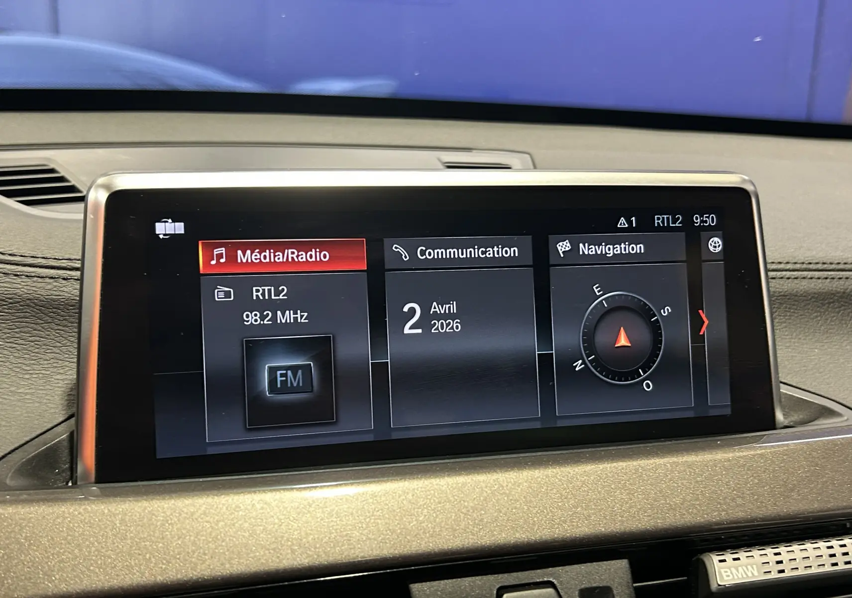 Écran central de la BMW X1 gris 2021 affichant les menus Média/Radio, Communication et Navigation en vue rapprochée.
