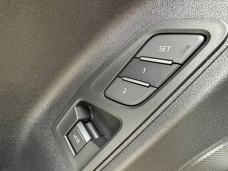 Détail des commandes de réglage mémoire des sièges et ouverture du coffre sur la porte côté conducteur d’un Audi Q3 noir Mythique.