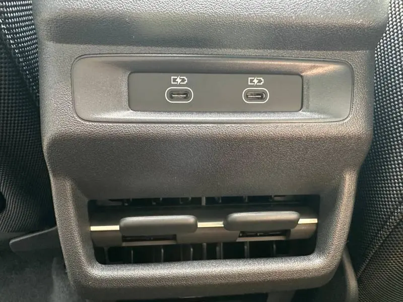Gros plan sur les ports USB-C de recharge et la sortie d’air arrière en plastique noir dans l’habitacle de l’Audi Q3 noir Mythique.