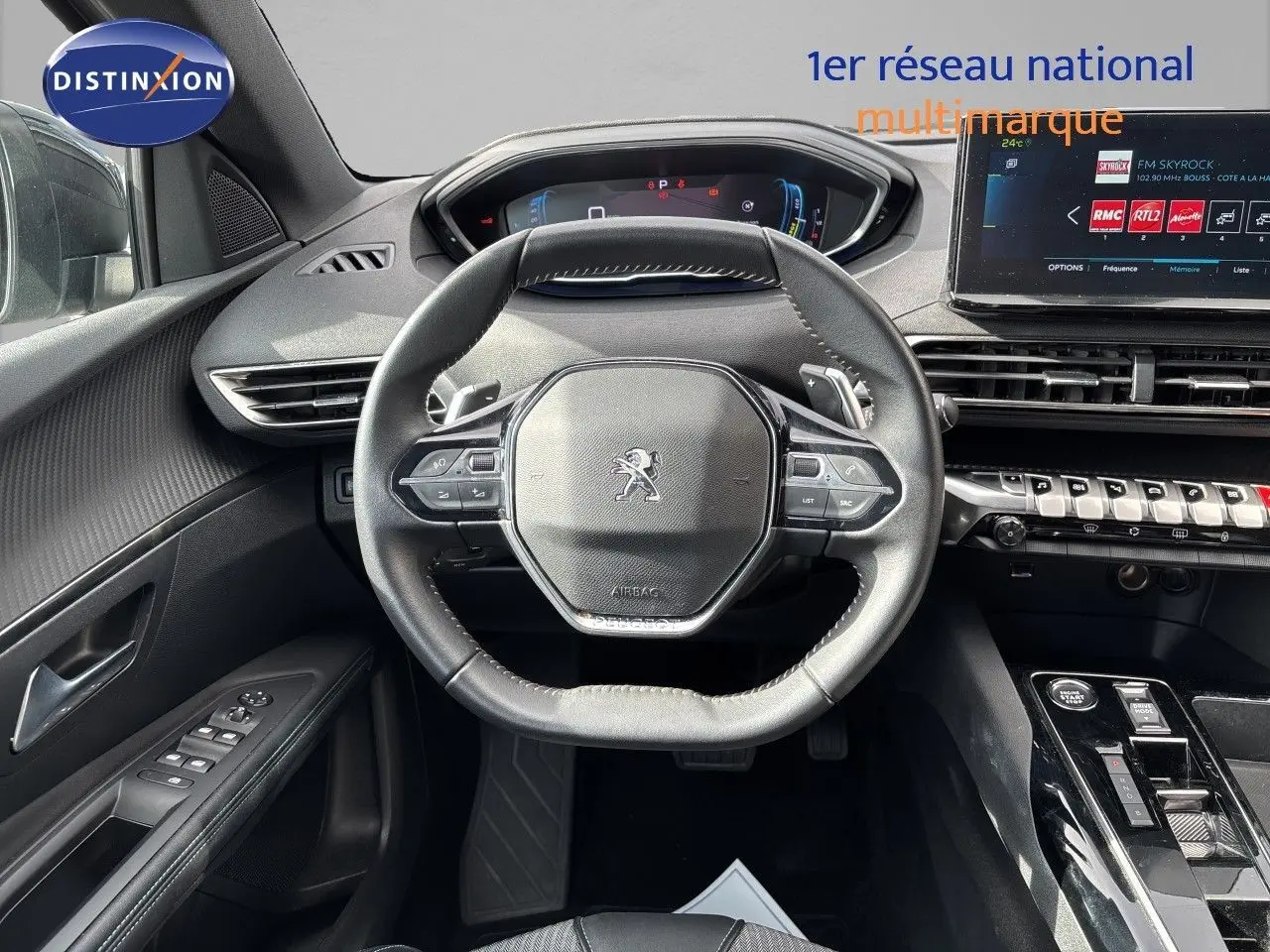 Vue intérieure centrée sur le volant cuir et le tableau de bord numérique du Peugeot 3008 gris platinium 2024.