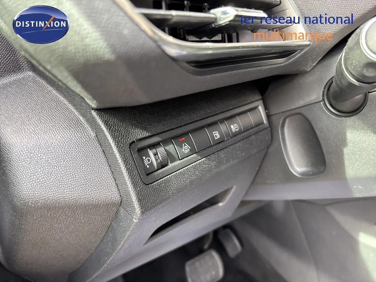 Détail intérieur du tableau de bord côté gauche du Peugeot 3008 Hybrid 180ch gris platinium, avec commandes et pédales visibles.