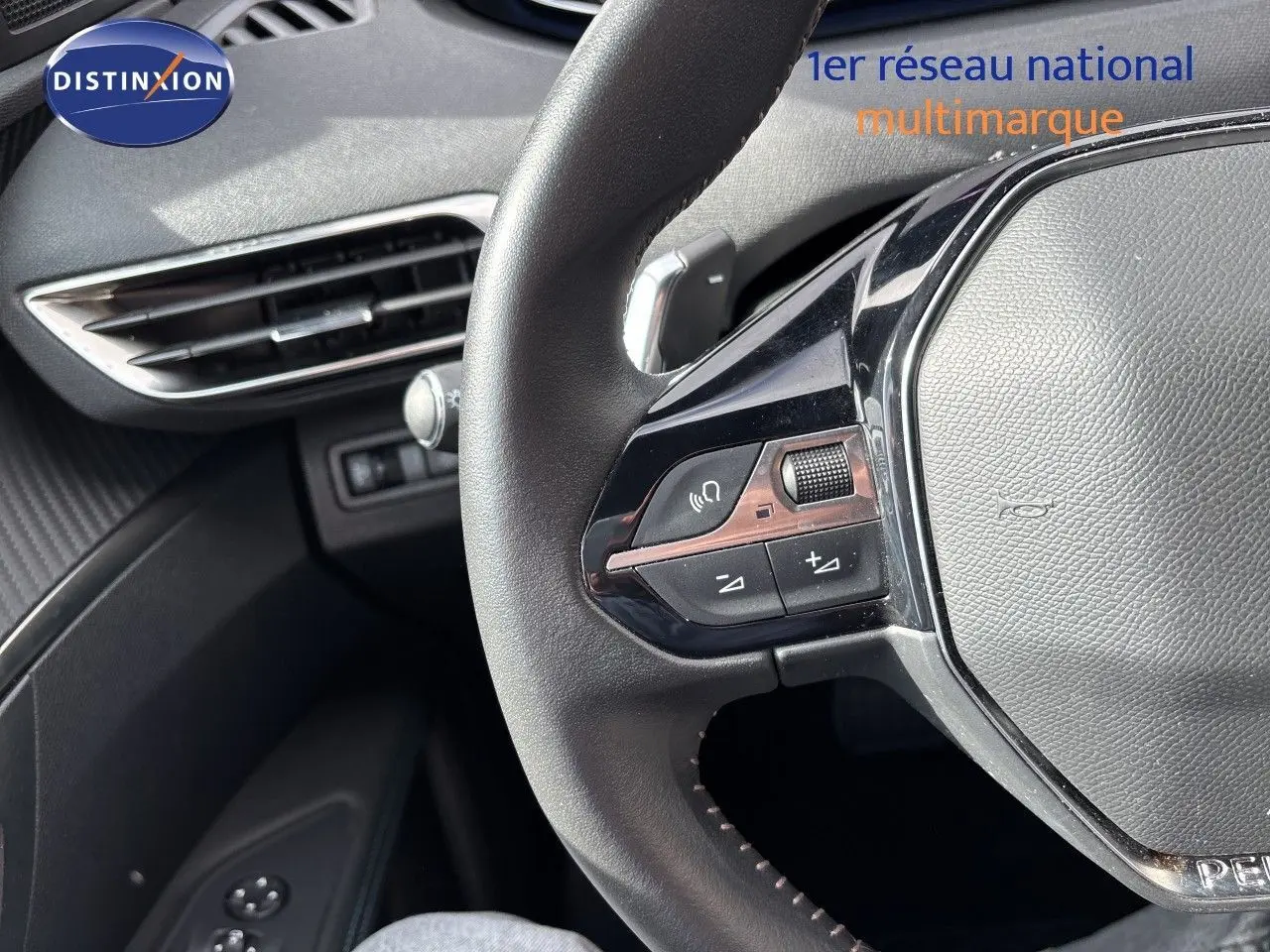 Gros plan sur le volant cuir noir de la Peugeot 3008 2024, montrant les commandes multifonctions côté gauche.