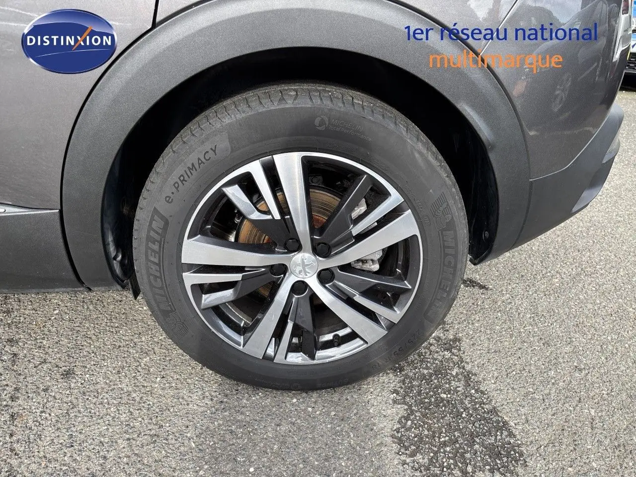 Gros plan sur la roue avant gauche du Peugeot 3008 gris platinium métal, avec jante alliage bicolore et pneu Michelin.