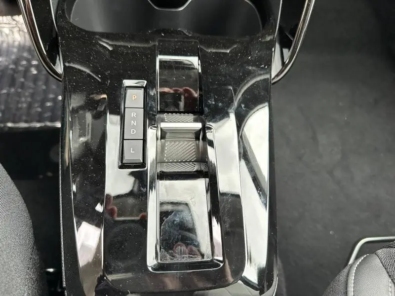 Vue plongeante sur la console centrale noire brillante avec sélecteur de vitesses et commandes du Citroën C3 Aircross 2026.