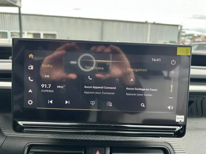 Écran tactile central de la Citroën C3 Aircross 2026 affichant radio, téléphone et navigation, intérieur noir.