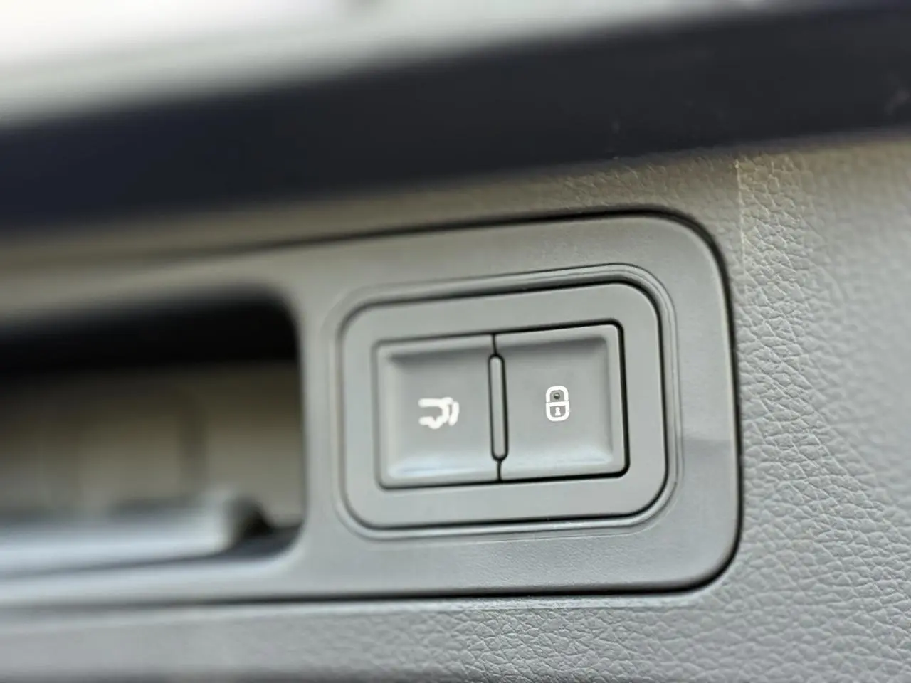 Gros plan sur les boutons d'ouverture du hayon et de verrouillage, intérieur noir du BYD SEAL U Snow White.