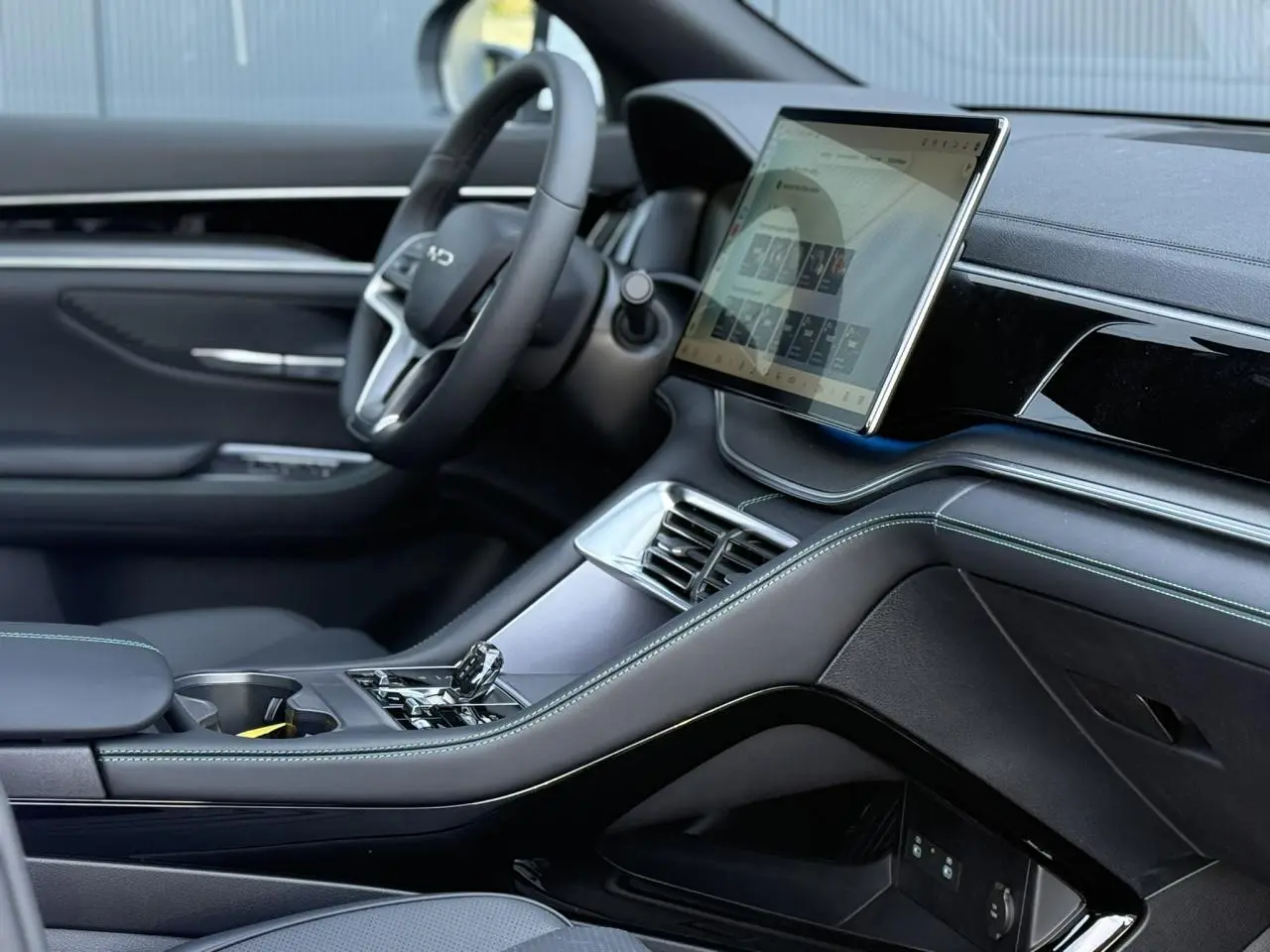 Vue intérieure côté conducteur du BYD SEAL U 1.5 DM-i 218 Boost avec écran tactile rotatif et sellerie noire élégante.