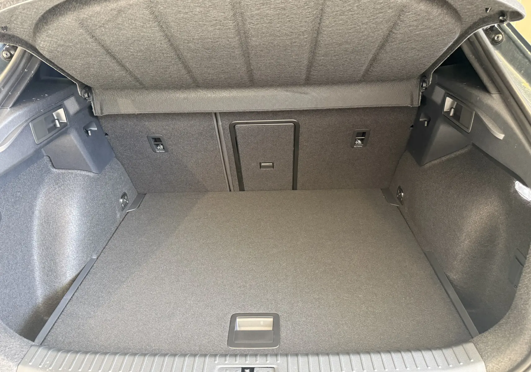 Coffre ouvert vu de l'arrière d'une CUPRA Formentor gris, montrant un espace de chargement propre et bien fini.
