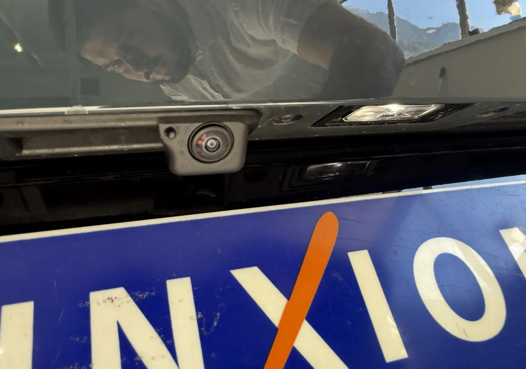 Gros plan sur la caméra de recul intégrée au hayon arrière du CUPRA Formentor gris, avec plaque d'immatriculation partiellement visible.