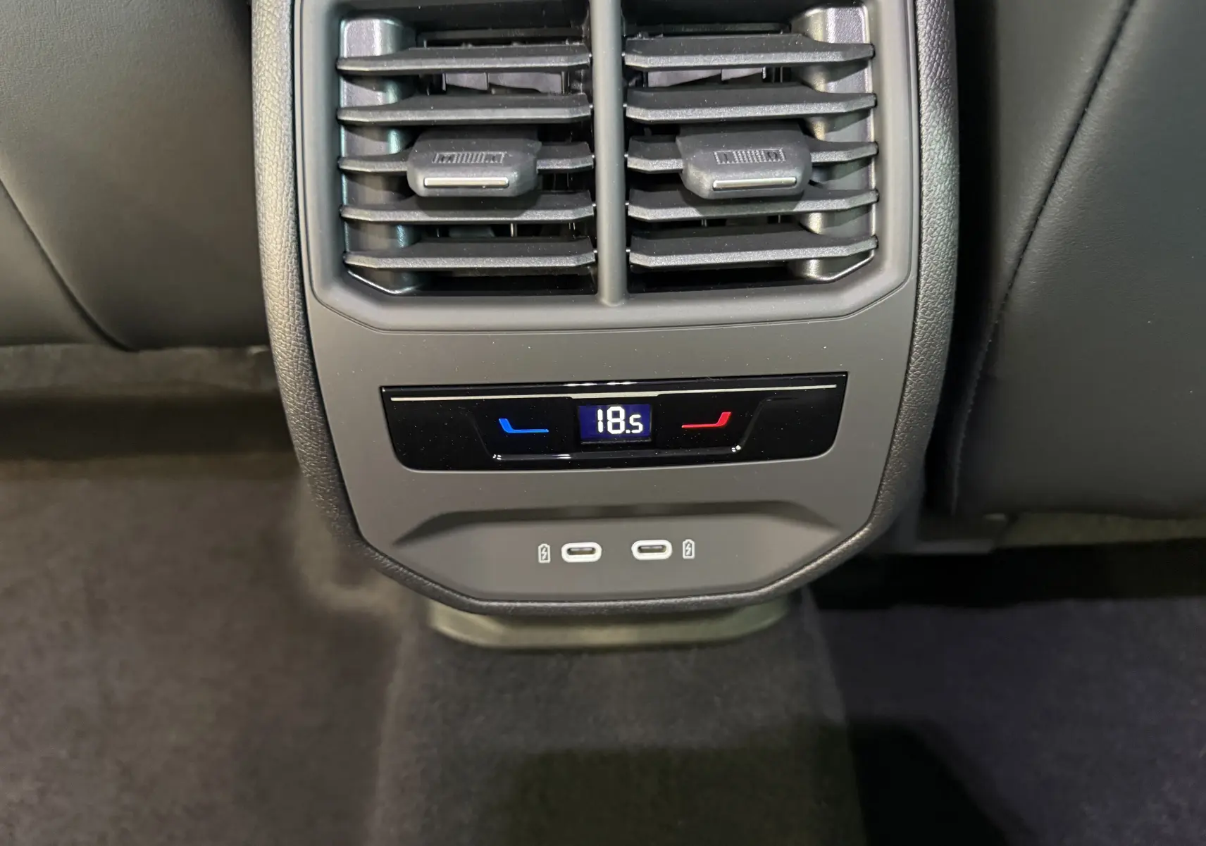 Vue rapprochée de la console arrière grise du CUPRA Formentor 2026, montrant les aérateurs et commandes de climatisation.