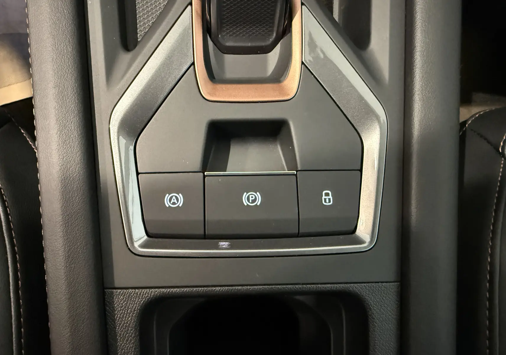 Gros plan sur la console centrale grise du CUPRA Formentor 1.5 eTSI 150CH DSG7 avec boutons de frein à main, auto hold et verrouillage.