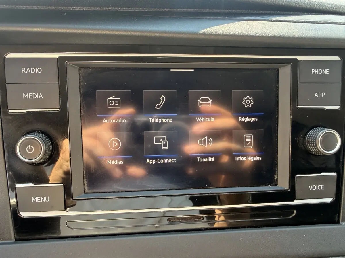 Écran tactile central du tableau de bord du Volkswagen Transporter gris clair, affichant les options multimédia.