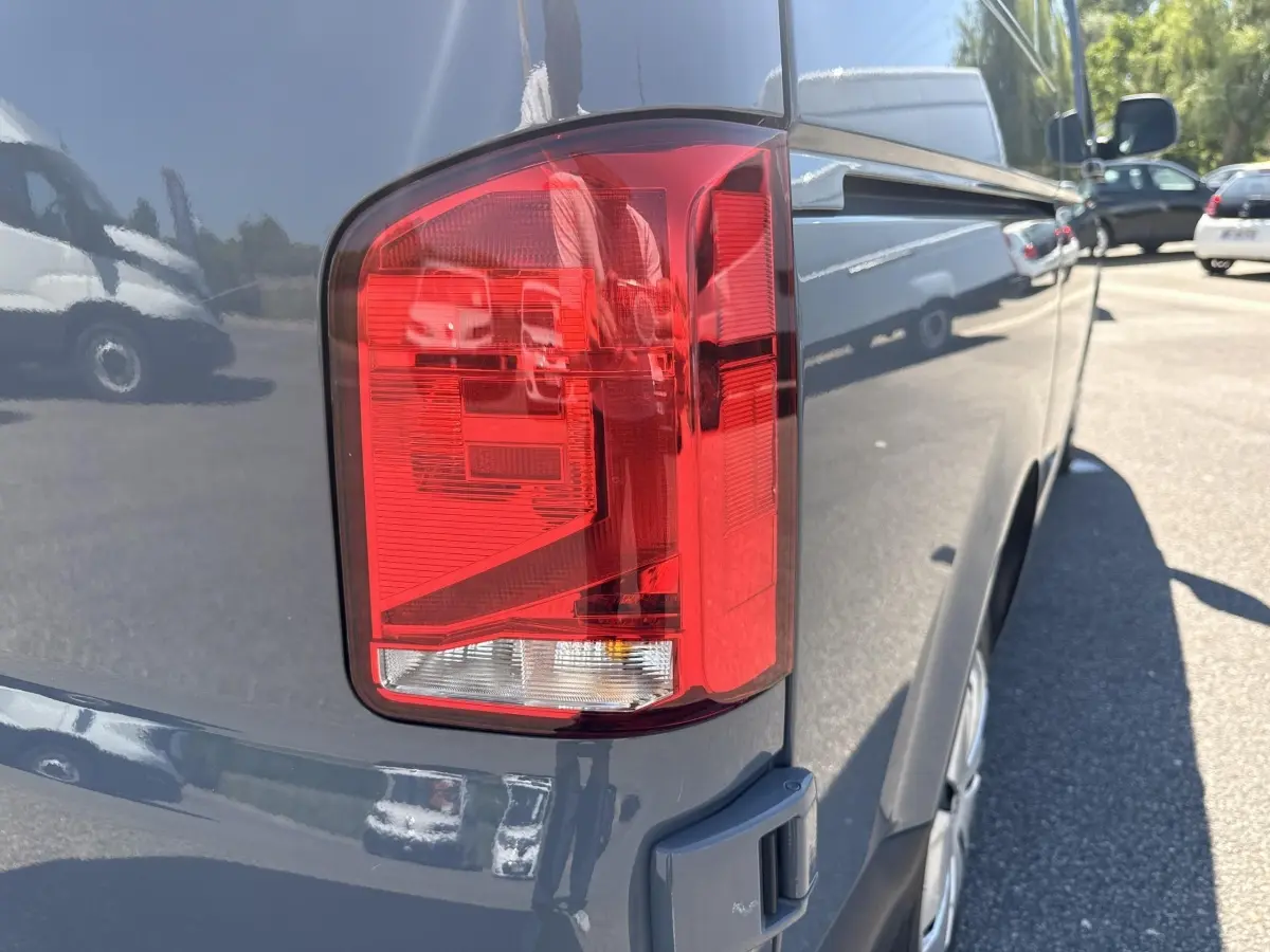 Gros plan sur le feu arrière droit d’un Volkswagen Transporter gris clair 2023, vue latérale arrière.