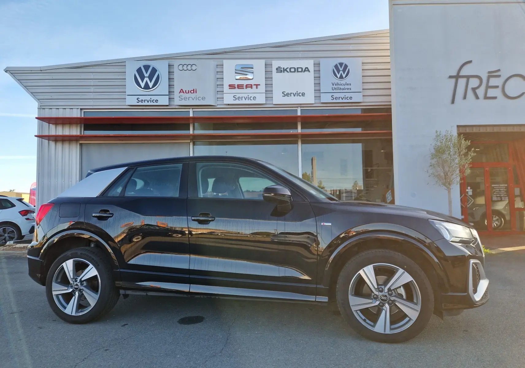 Audi Q2 35 TFSI S line noir vue de profil côté gauche, avec jantes alliage et toit contrasté gris clair.