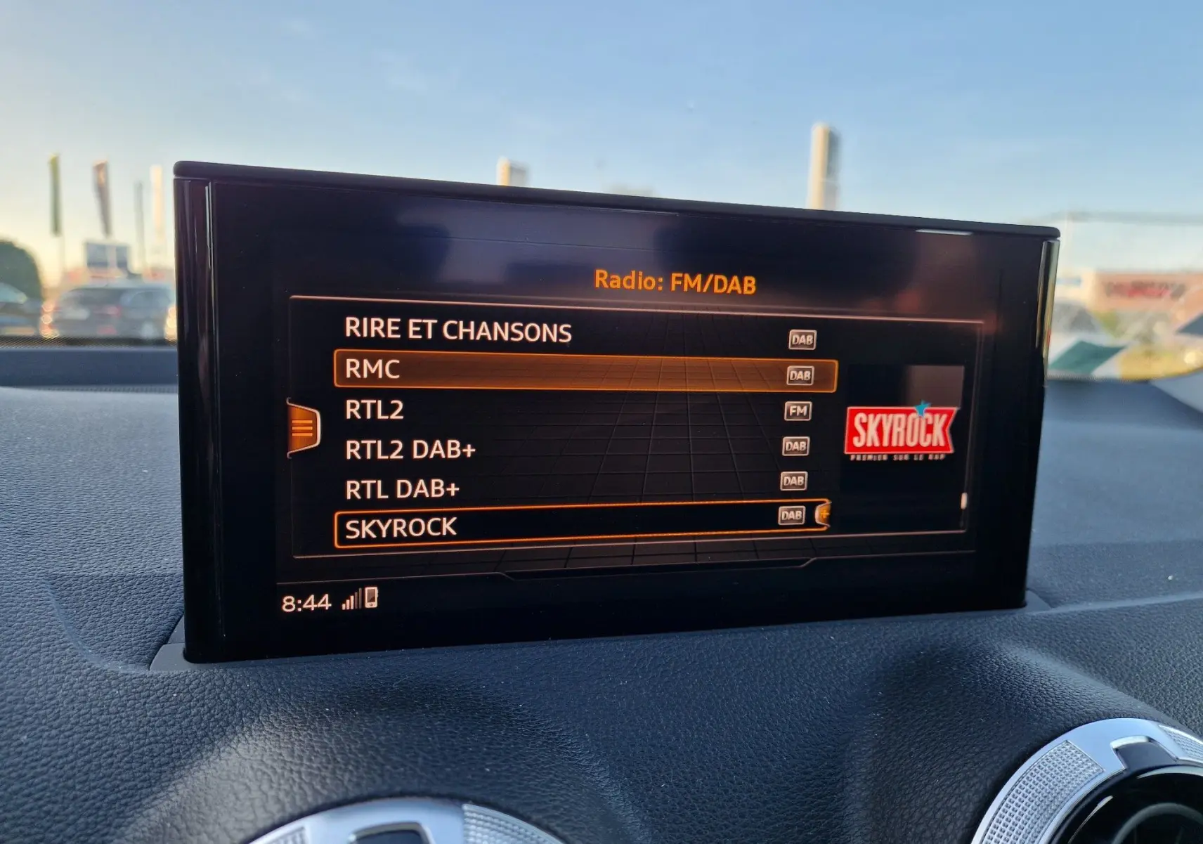 Écran central de l’Audi Q2 35 TFSI 2021 affichant les stations radio FM/DAB avec sélection sur Skyrock, intérieur noir.