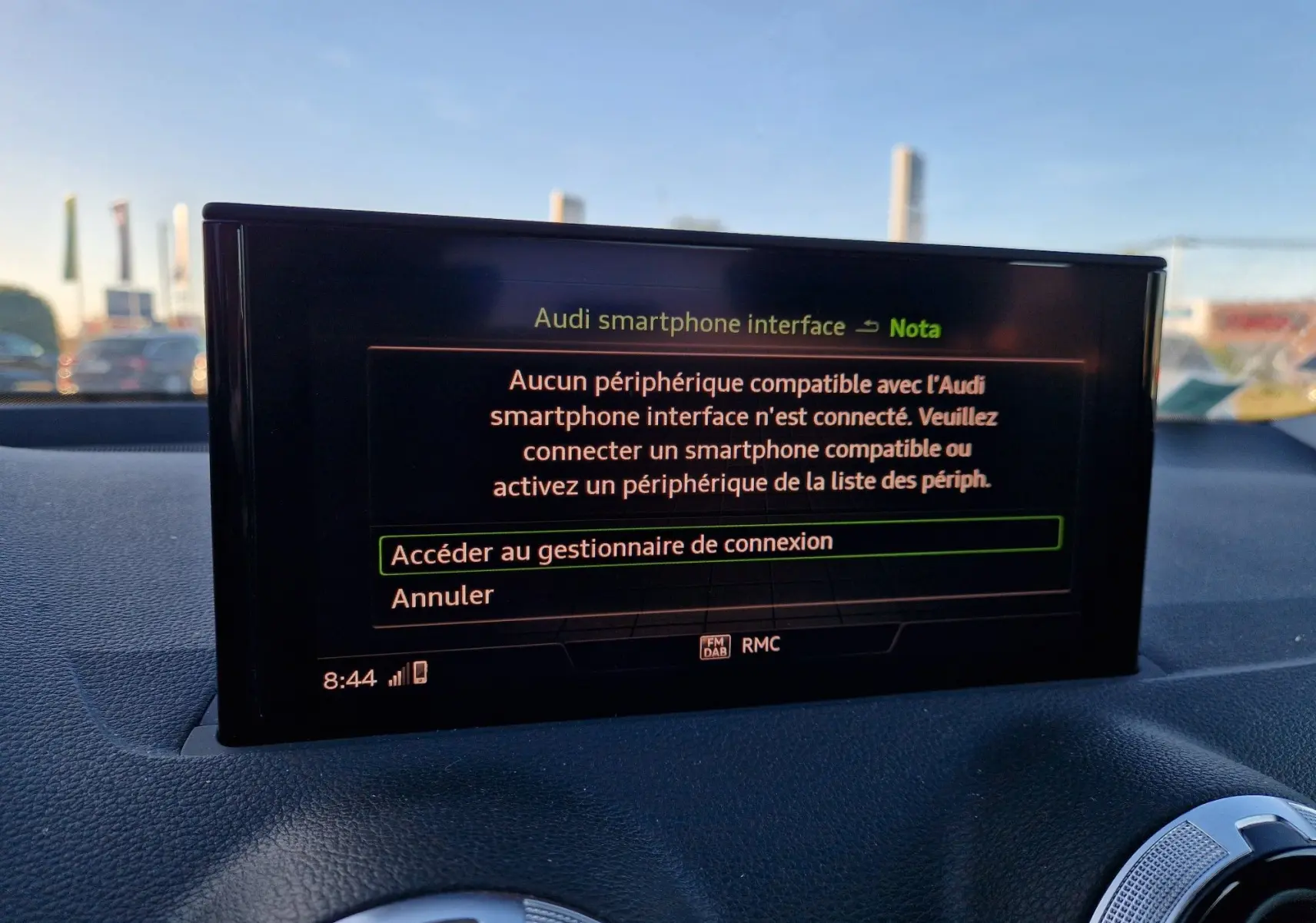 Écran central de l'Audi Q2 noir affichant le menu de connexion smartphone, avec tableau de bord et aérateurs visibles.