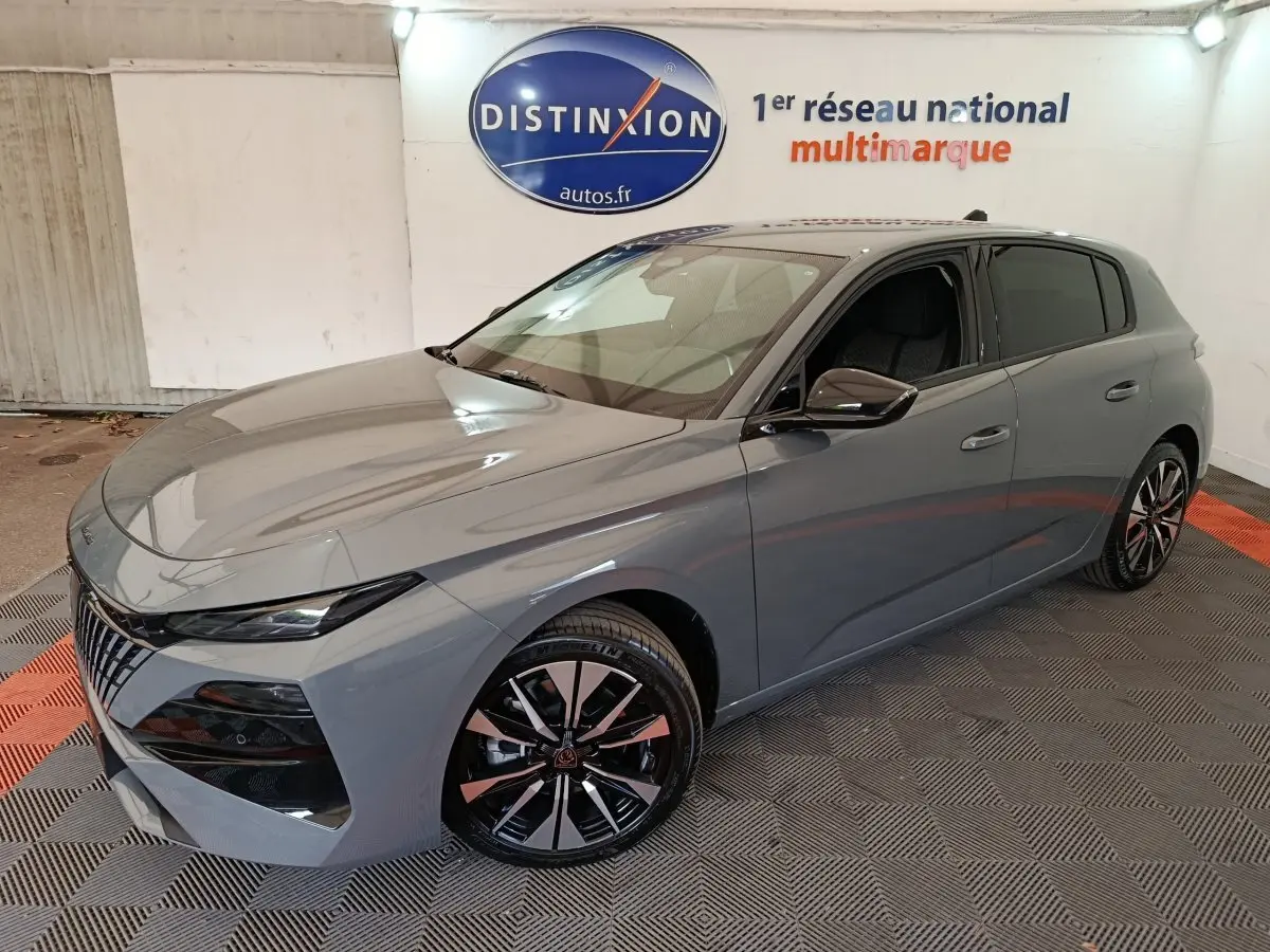 PEUGEOT 308 BlueHDi 130 gris foncé en 3/4 avant droit, avec jantes alliage et calandre distinctive.