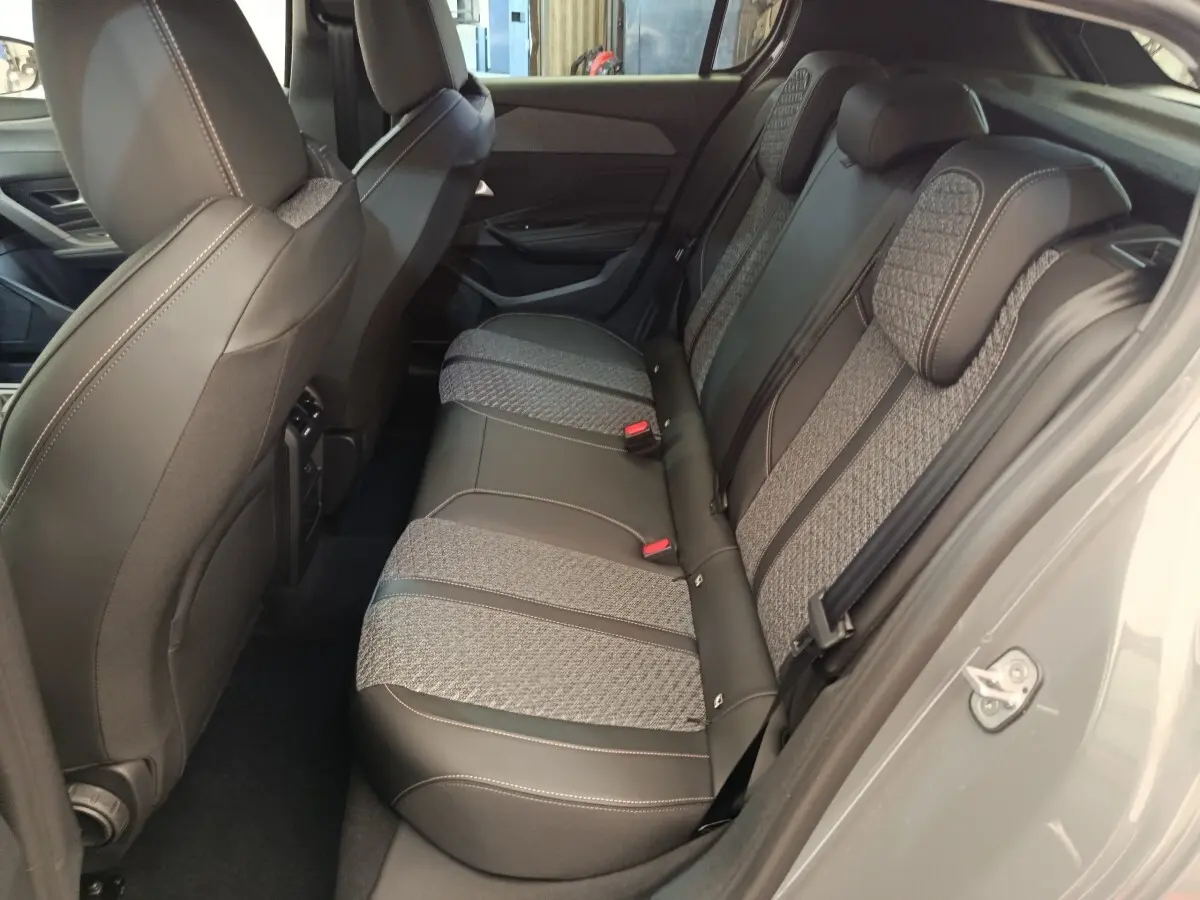 Vue intérieure côté droit des sièges arrière en tissu et cuir gris de la Peugeot 308 BlueHDi 130 CH EAT8 ALLURE 2026.