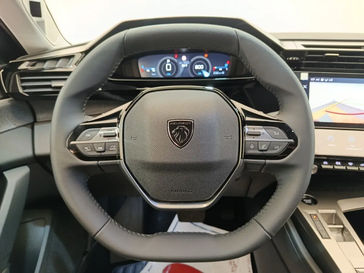 Volant cuir multifonctions noir de Peugeot 308 2026 avec tableau de bord numérique et écran tactile central visible.
