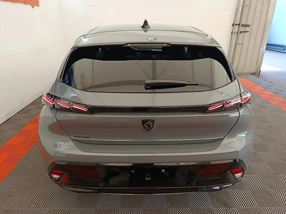 Vue arrière d'une Peugeot 308 gris foncé avec feux LED distinctifs et lunette arrière teintée.
