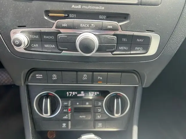 Tableau de bord de l'Audi Q3 2015 avec commandes multimédia et climatisation automatique affichant 17,5°C.