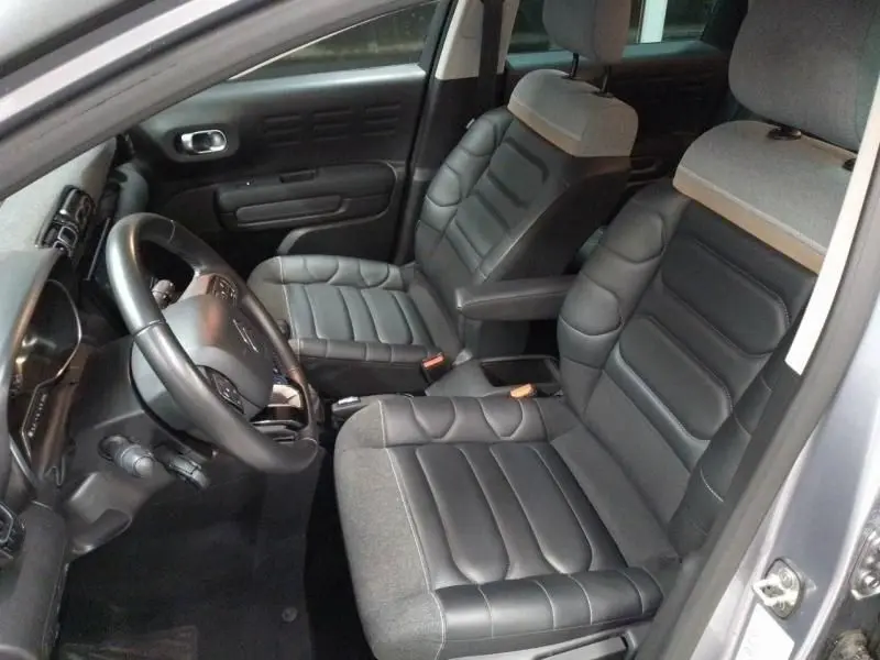 Intérieur côté conducteur de la Citroën C3 Aircross 2022 gris, sièges en cuir et tissu bicolore avec volant multifonction.