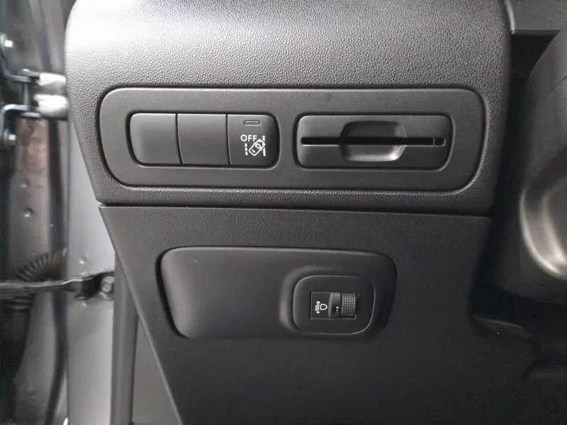 Vue rapprochée des commandes de réglage des phares et de la stabilité sur le côté gauche intérieur d'une Citroën C3 Aircross gris 2022.