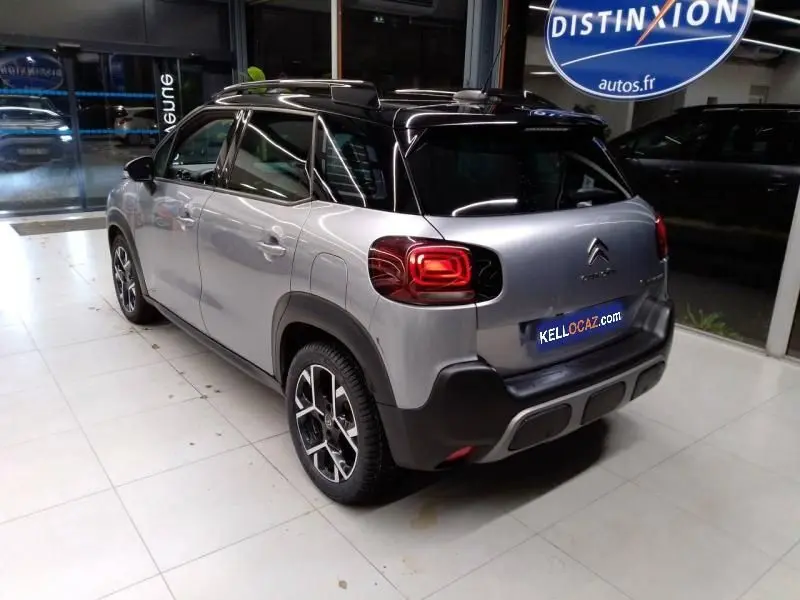 Vue 3/4 arrière droite d'un Citroën C3 Aircross gris 2022 avec toit noir et feux arrière LED distinctifs.