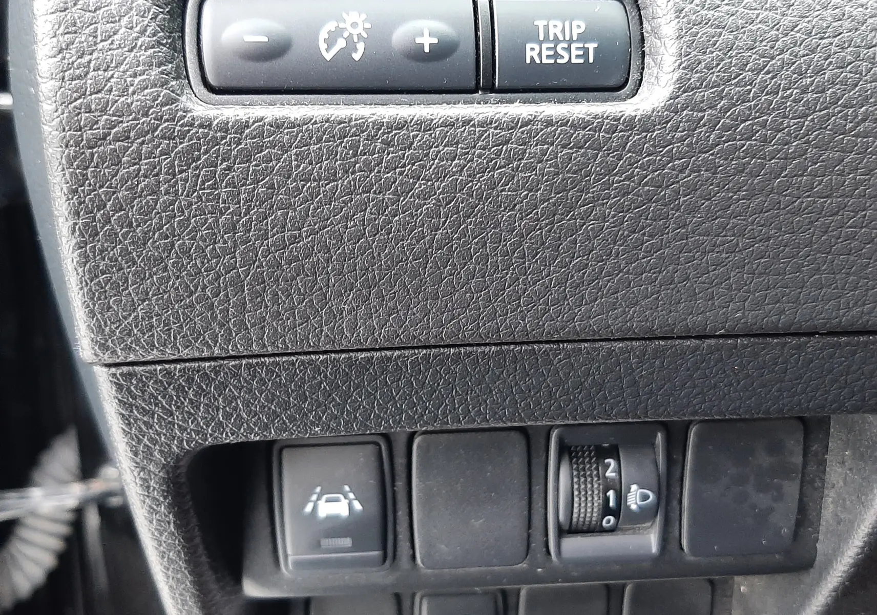 Détail du tableau de bord noir du Nissan Qashqai DCI 115 N-Connecta 2020 montrant les commandes de régulateur, assistance de voie et réglage des phares.