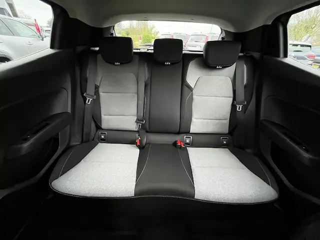 Vue intérieure arrière de la banquette 3 places de la Renault Clio noire, avec sièges bicolores gris et noir et appuie-têtes.