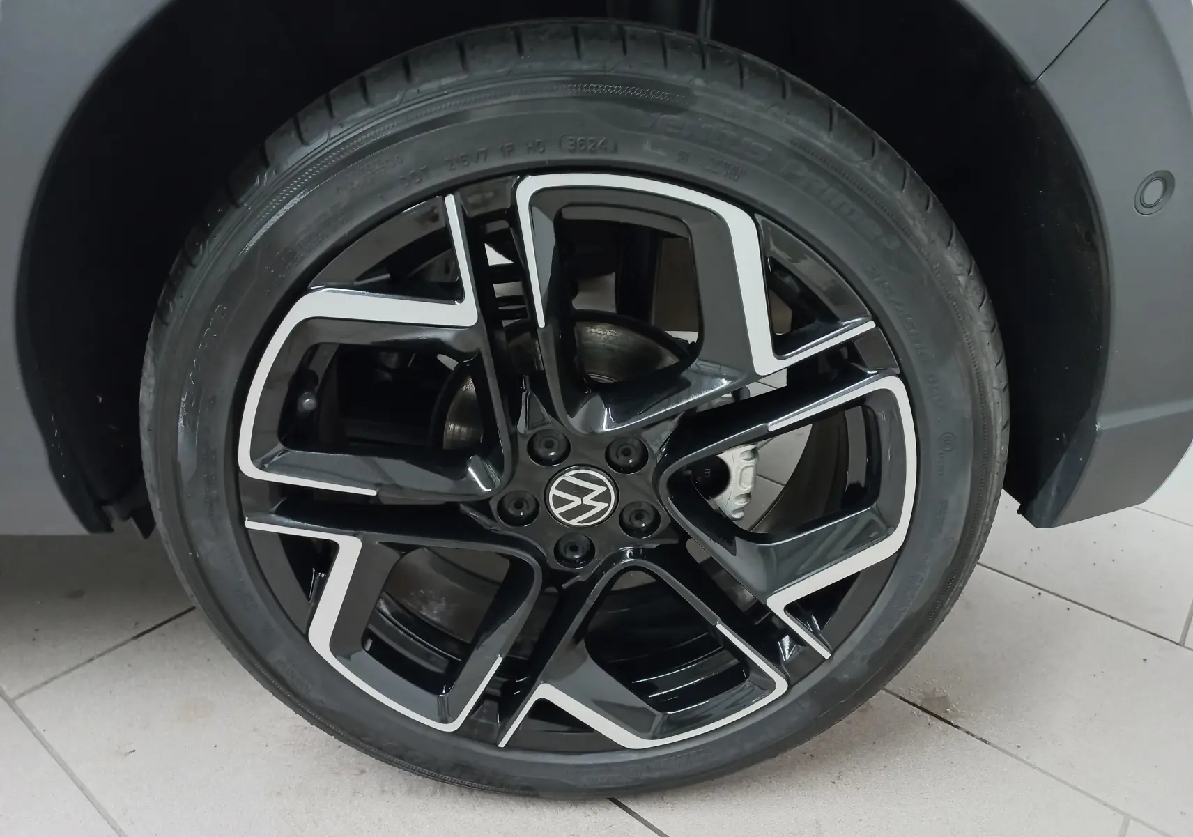 Gros plan sur la jante noire et argentée du Volkswagen Taigo 1.5 TSI 150 DSG7 R-Line Edition blanc pur, roue avant droite.